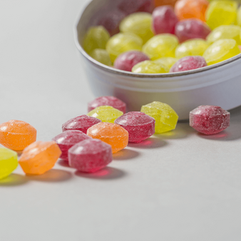 Dose, farbig bedruckt, liegend mit Süßigkeiten